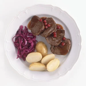 Slices of venison served with potatoes, red cabbage, redcurrants and sauce, a typical Scottish dish, view from above