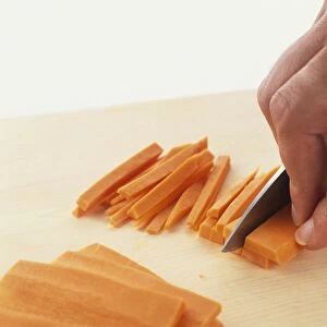 Slicing carrots into thin strips, close-up