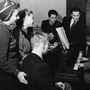 Soviet composer, dmitri shostakovich, at his piano with a group of students from his theory and composition class, moscow, ussr, october 1947