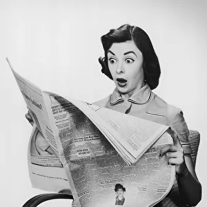 Surprised woman reading newspaper
