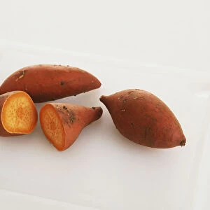 Three sweet potatoes, one of them cut in half