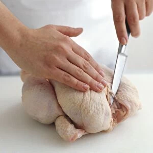Using sharp knife to expose wishbone of chicken, close-up