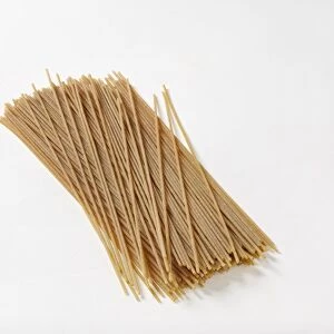 Wholewheat spaghetti against white background