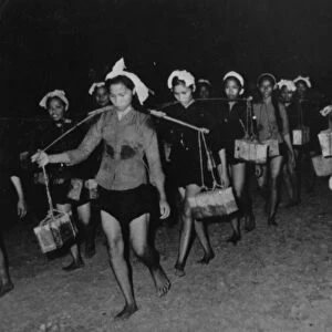 A womens unit carrying supplies to the south vietnam peoples liberation army forces along the ho chi minh trail at night, vietnam war, 1968