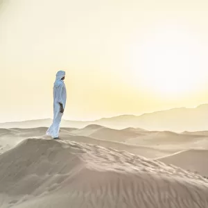 Arab man standing in sand dunes near Dubai