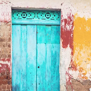 Old and beautiful turquoise door and old multicorored facade at house