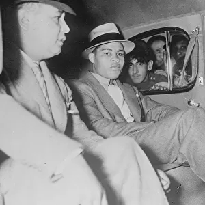 Joe Louis seated calmly in his car as admirers press their faces eagerly to the windows