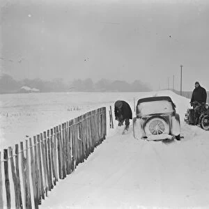 Motorist tries to dig his car out of the snow on Polhill near Orpington