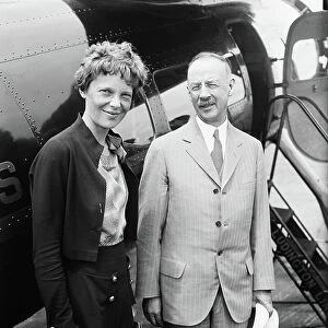Amelia Earhart (L), Portrait with Man in front of Airplane, 1932 (b/w photo)