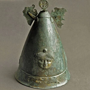 Apulian helmet adorned with a medusa head and a representation of a dog fighting a boar. 4th century BC (bronze)