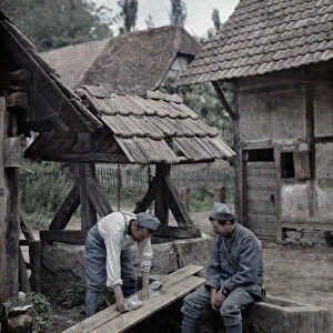 Two French soldiers are taking care of their laundry using boards set up on the trough of