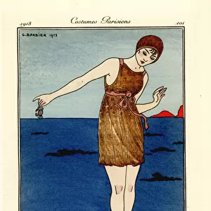 Woman in swimming costume up to her ankles in the sea on a beach holding a crab. Costume de bain. Handcoloured pochoir (stencil) etching after an illustration by George Barbier from Tommaso Antonginis Journal des Dames et des Modes