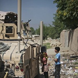 Afghan children ask U. S. soldiers in their humvee for candy