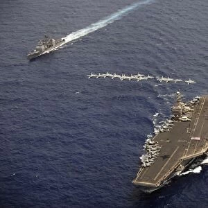 F / A-18 Hornets fly in formation over USS Abraham Lincoln and USS Cape St. George