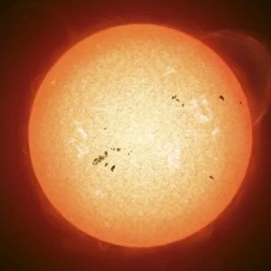 Illustration of the sun with visible dark sunspots on the surface, prominences