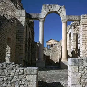 Distant Roman capitol of Dougga seen through an arch, 2nd century