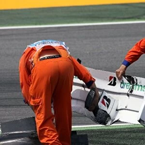 Formula One World Championship: The broken front wing of Rubens Barrichello Honda RA108 is removed from the track by marshalls