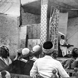 World war one photograph in Iraq (Mesopotamia), British Royal Engineers. A theatre in Iraq with music and dancing and the audience looking on. A manual fan suspended above the stage; Iraq