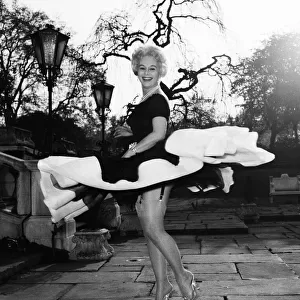 Actress Eva Gabor gives a twirl in her dress April 1957
