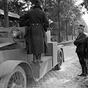 Belgian officers talk to the crew of an armoured car during a lull in the fighting in