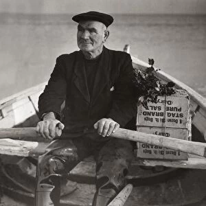 Boatman Old Alick rows the holly-topped Christmas boxes from the families ashore out to