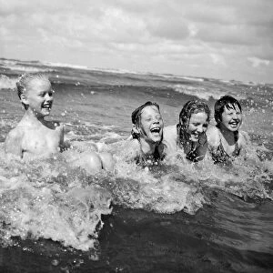 Four children enjoy a swim in the sea at Blackpool beach in the summer holidays