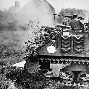 One of a column of camouflaged M7 tanks blasts away with another round at German