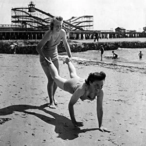 A couple of girls have some fun on the sandy beach at Clacton on sea