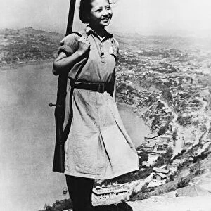 Female Guerilla fighter armed with weapon smiles for the camera during Second World War