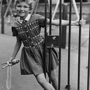 Girl seen here playing with skipping rope. She is wearing a dress which is similar to