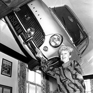 Lynne Stevens, assistant manager, polishes the 1962 Ford Consul in the lounge of