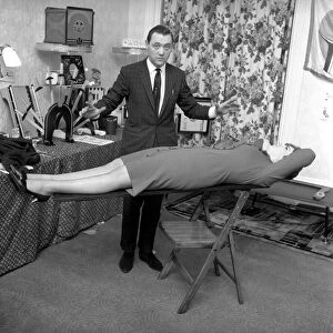 Magician Bernard Hughes: Performing a levitation trick on his female assistant