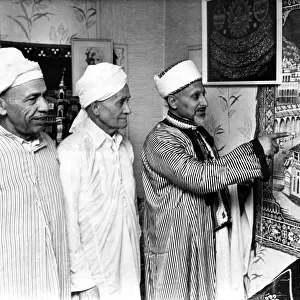 Mr Saleh Hassen of Loudon Square showing a tapestry of Kaaba Mecca to two members of