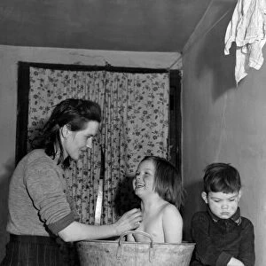 Mrs Florence Kavanagh bathes her daughter Theresa and son Michael