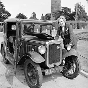 Mrs Goul looks under the bonnet of her car following a breakdown on the village green