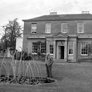 Novelist J. B. Priestley in the garden of his home, Kissing Tree House in the village of