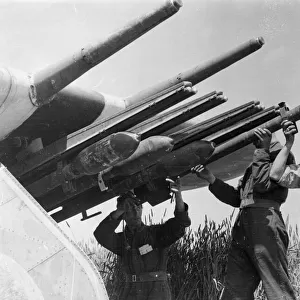 R. A. F ground crew equipping Typhoons with rocket projectiles at a landing strip in France