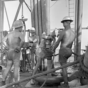 Roughnecks working on a oil production platform drilling for oil just off the coast of