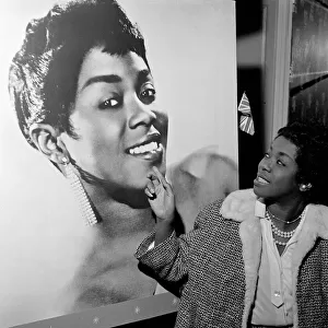 Sarah Vaughan at the Satire Club, London pointing at portrait of herself