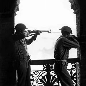 Soldiers of the Chinese defence force in Shanghai uniform with rifles take aim as they