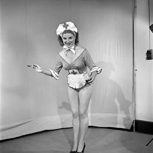 A spoonful of medicine: Woman wearing comic nurses uniform. 1959