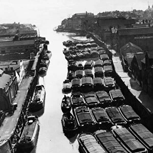 Tugs, lighters and barges moored to the staithes awaiting to unload their goods into