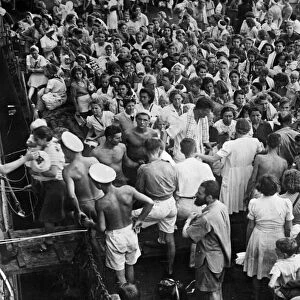 Women and children internees from Surabaya boarding HMS Bulolo, bound for Singapore