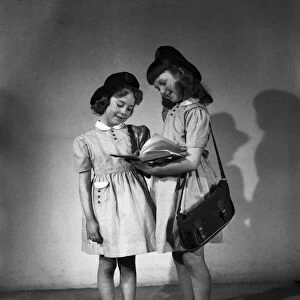 Two young girls model in their school uniforms for a Daily Herald feature titled "