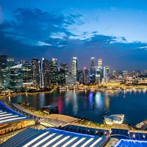 Aerial view of Singapore business district skyline with tourist sightseeing in night at Marina Bay, Singapore. Asian tourism, modern city life, or bus