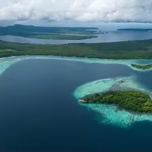 A healthy, robust coral reef surrounds a scenic bay in the Solomon Islands. This beautiful country is home to spectacular marine biodiversity